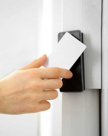 Employee using a access control key card to enter workplace